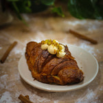 Pistachio Strawberry Twice Baked Croissant on a plate in a bakery.