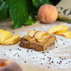 Palisade peach puff on a bakers bench with flour and sliced peaches.