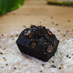 Noir Chocolate Zucchini Cake on a baker's bench with flour.