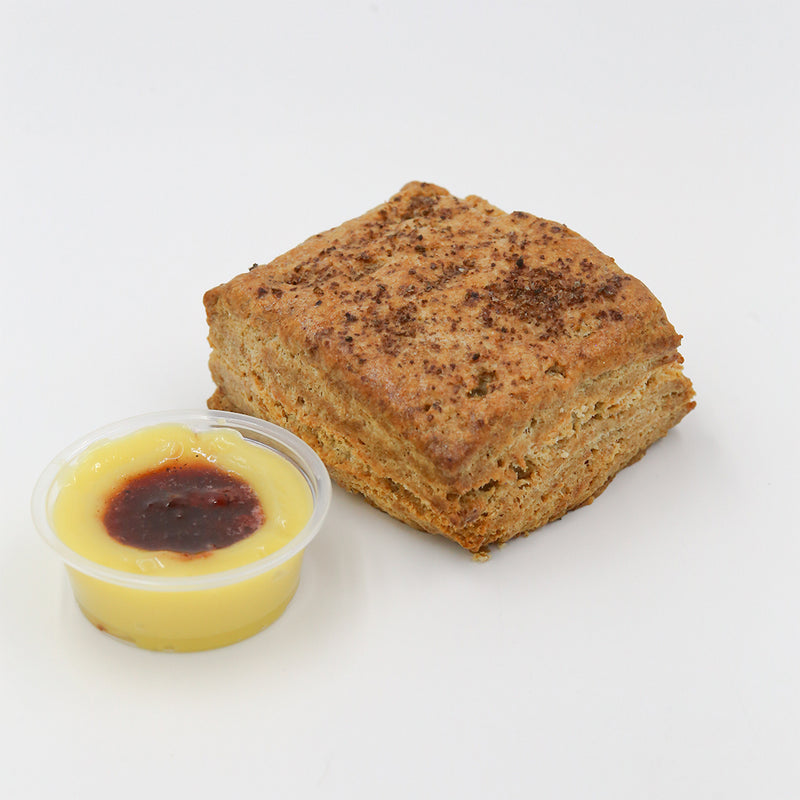 Bacon Fat Biscuit with Lemon Curd and Strawberry Pepper Jam on a white background.
