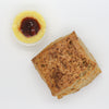Bacon Fat Biscuit with Lemon Curd and Strawberry Pepper Jam on a white background.